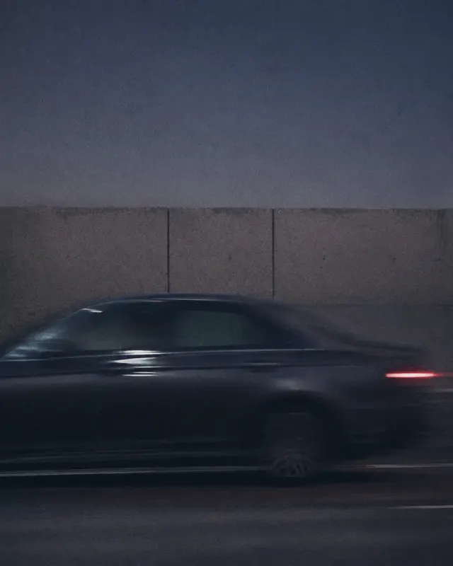 Auto en movimiento junto a un muro de hormigón